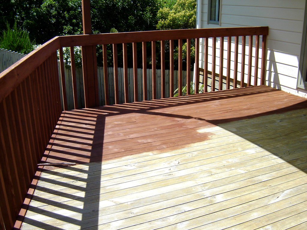 Elevated deck build with painted railings against a blue sky